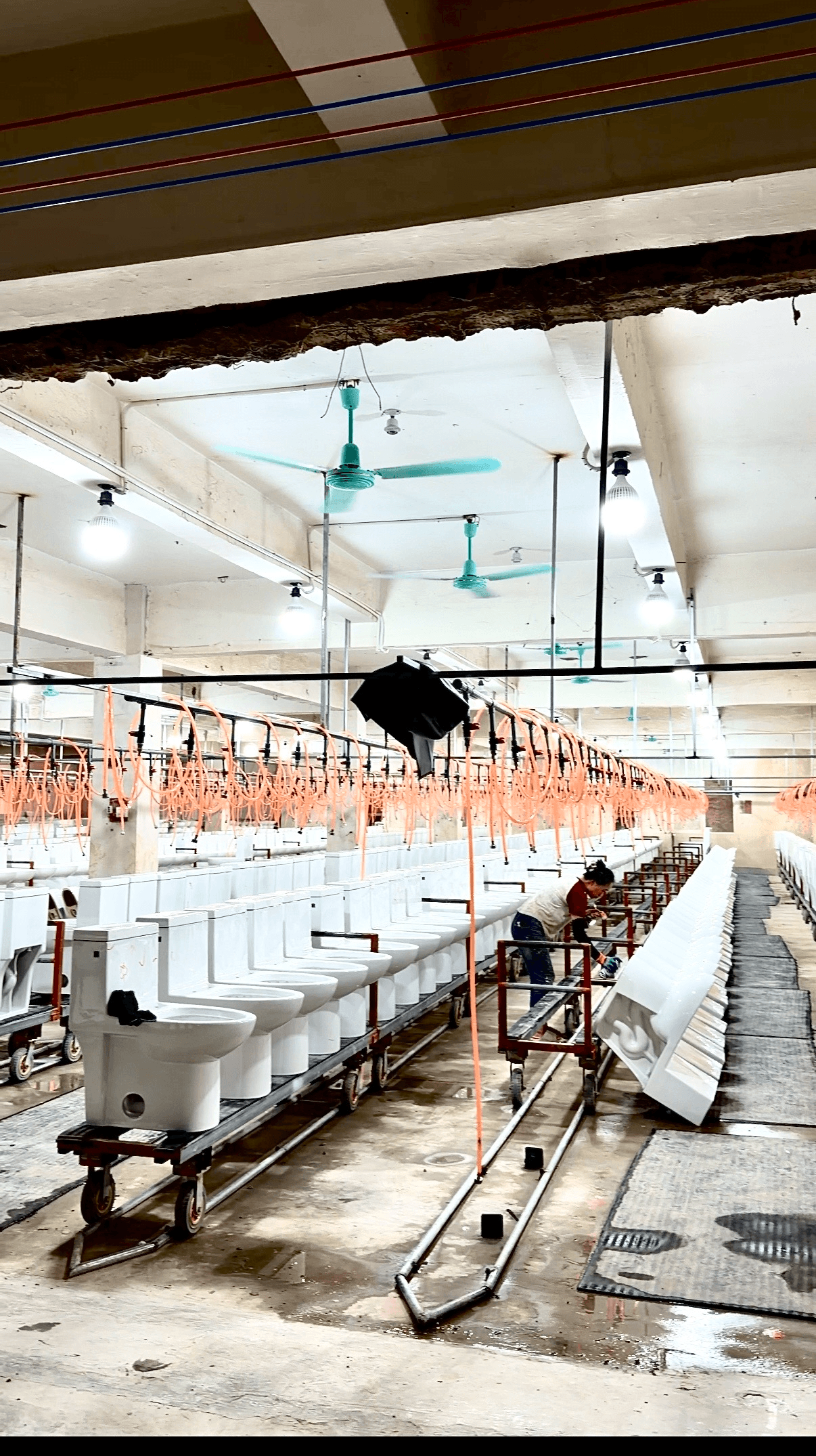 Rows of finished ceramic toilets stocked inside a partner manufacturer's factory